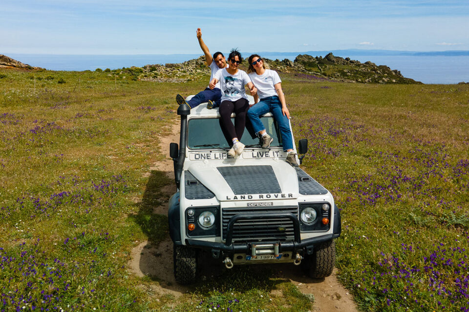 imagen de 3 chicos subidos a un todoterreno 4x4 al hacer una excursión por el parque nacional de asinara